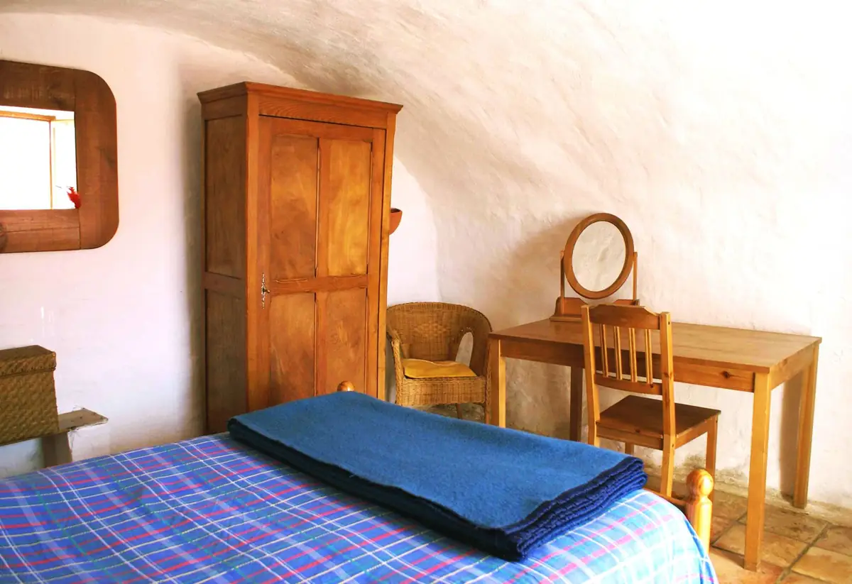 La chambre voûtée, avec son armoire ancienne et son lit à la couverture bleue
